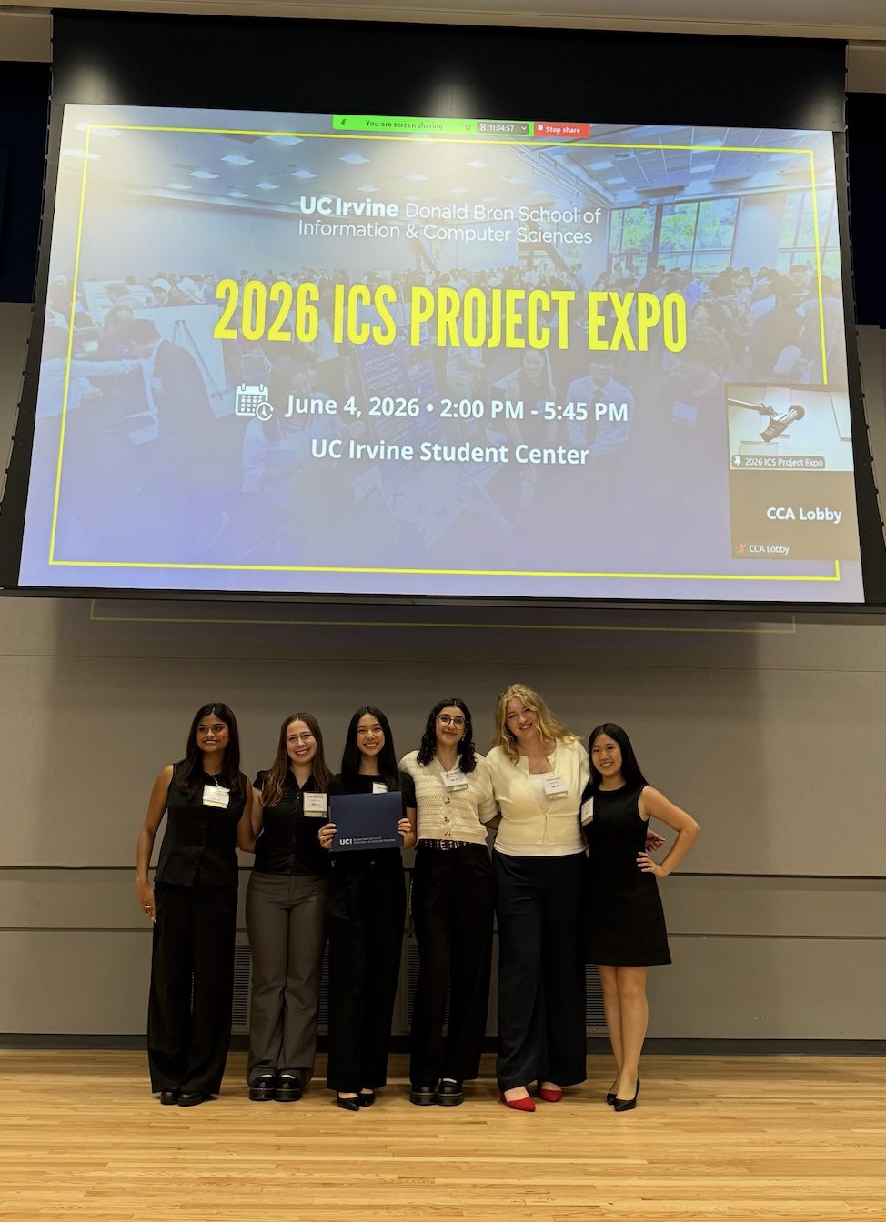 The team on stage under the 2026 ICS Project Expo banner, holding an award folder